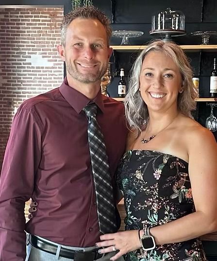 Spacious, well-lit garage with three white garage doors, shelving, and speckled flooring.