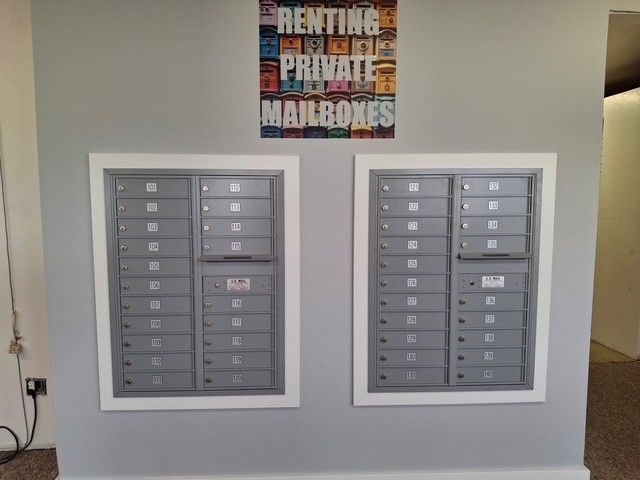 Two silver mailbox units built into a gray wall.