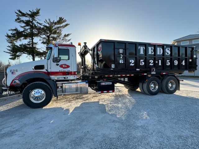 White dump truck with black container parked on snowy ground