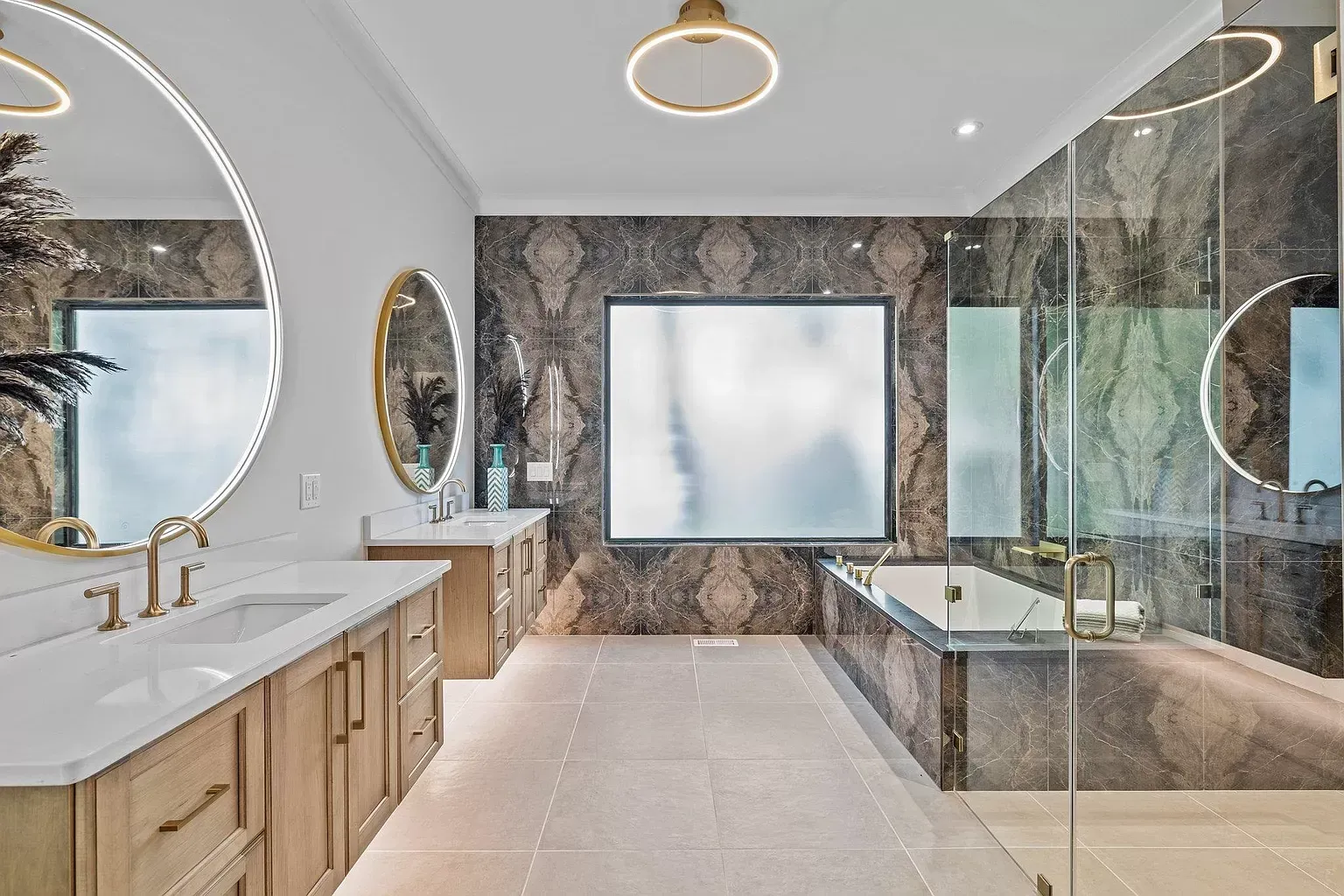 A bathroom with a tub , sink , mirrors and a walk in shower.