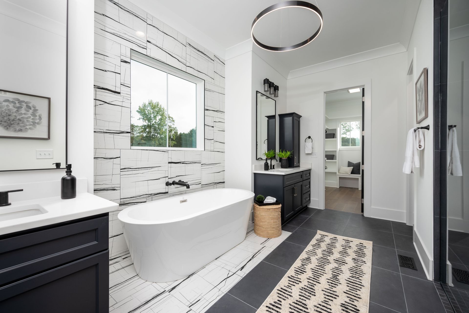 A bathroom with a bathtub , sink , mirror and rug.