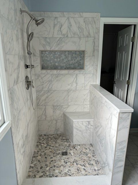 A bathroom with a walk in shower and a window.