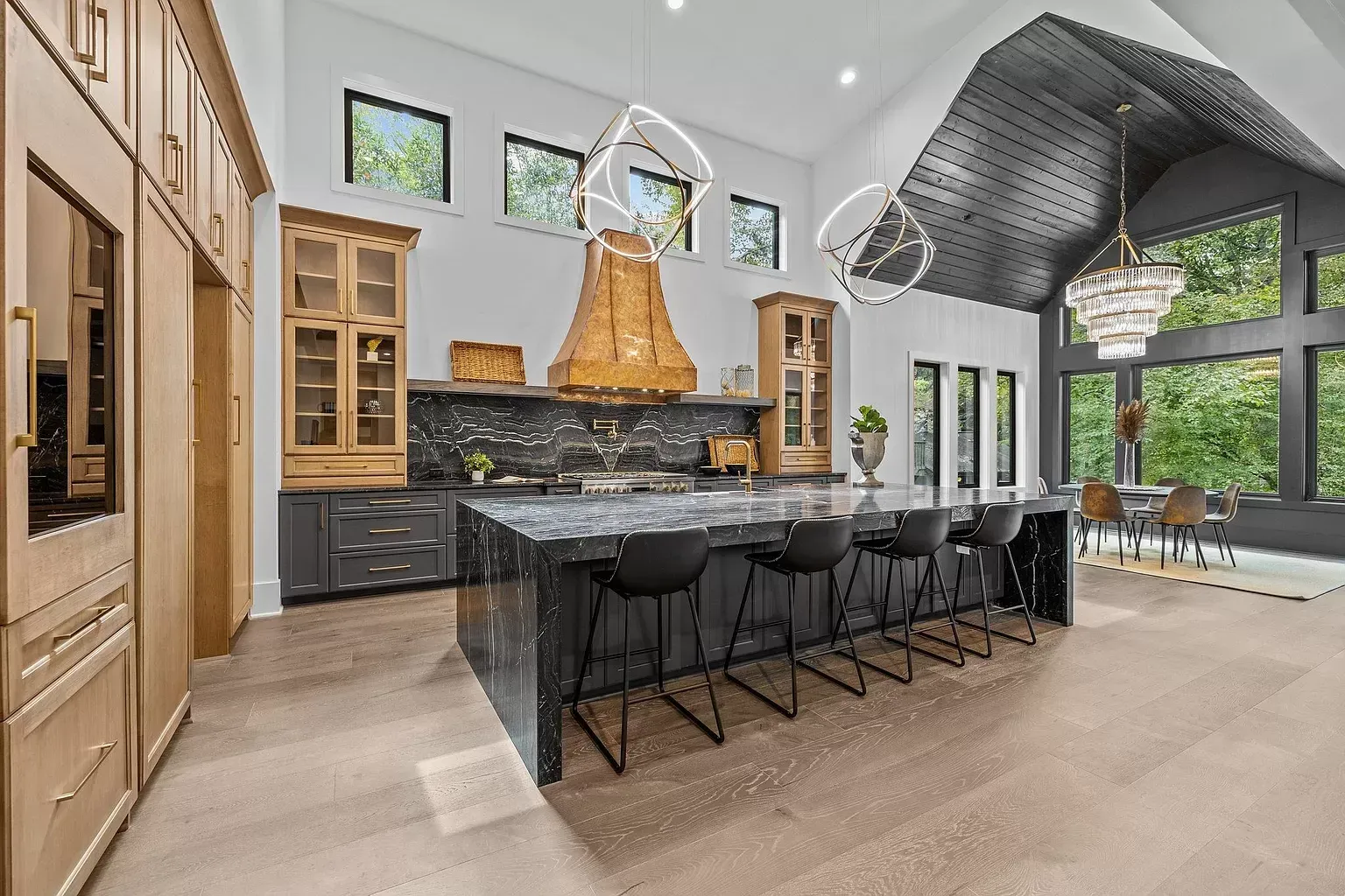 A large kitchen with a large island and lots of windows.