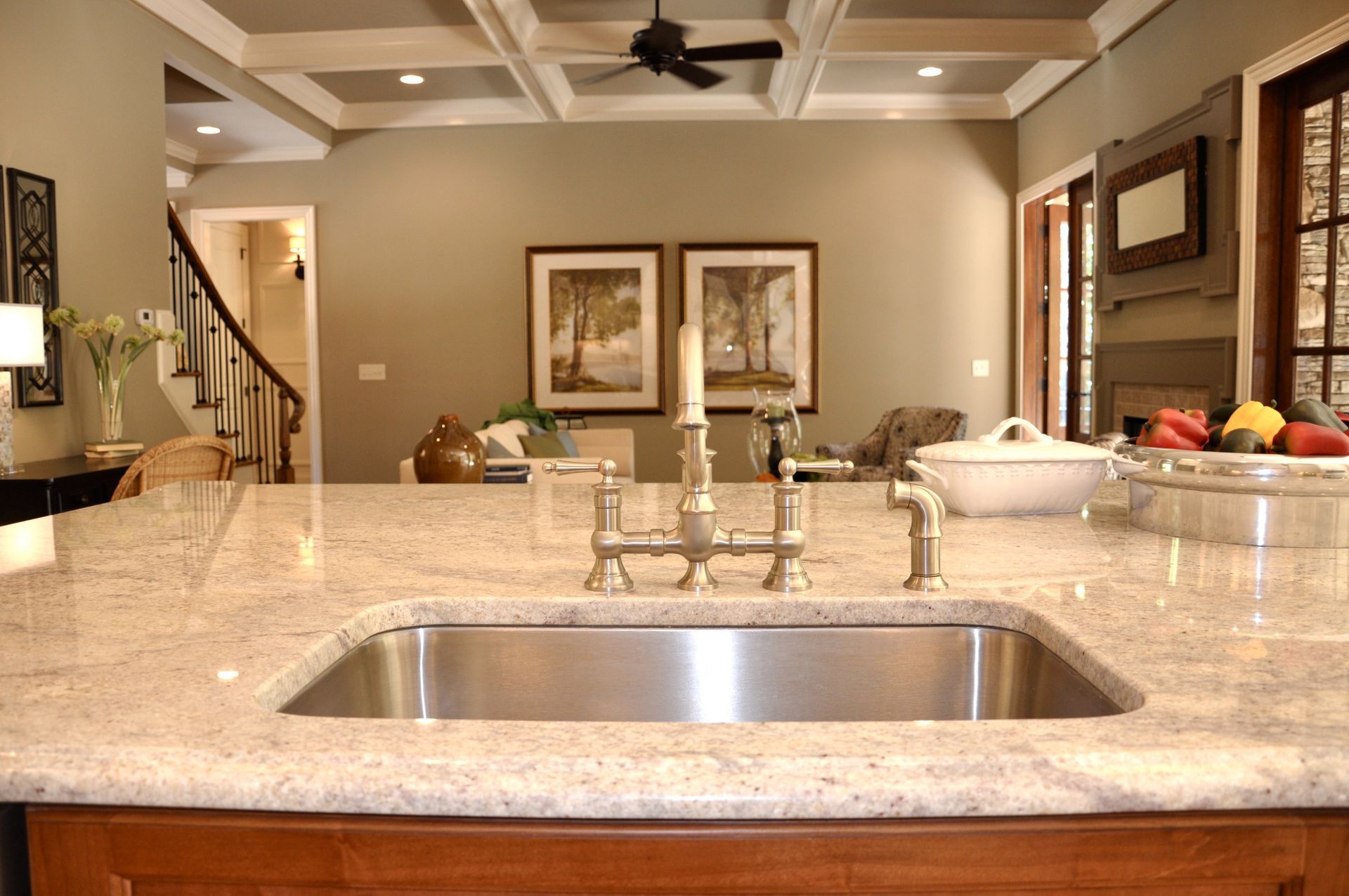 A kitchen with a stainless steel sink and granite counter tops