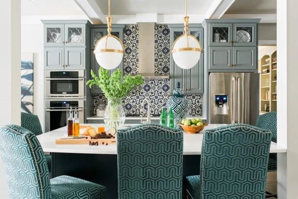 A kitchen and dining room with blue chairs and a large island.