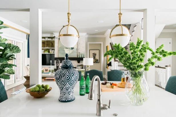A kitchen with a sink and a vase of flowers on the counter.