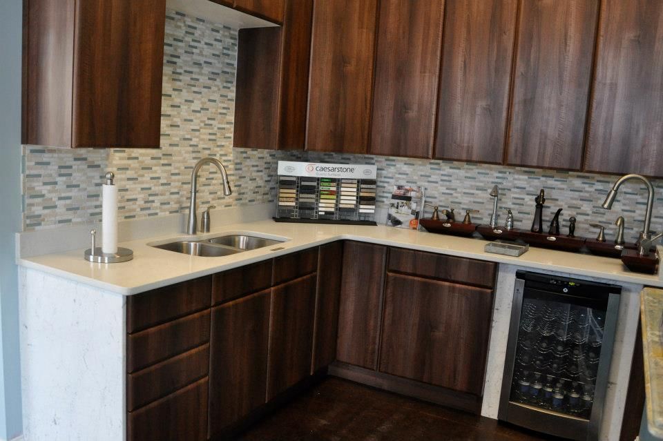 A kitchen with wooden cabinets , a sink , and a refrigerator.