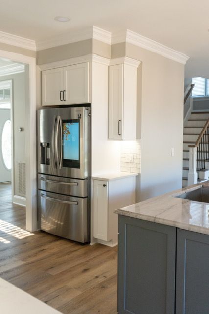 A kitchen with a stainless steel refrigerator and a sink
