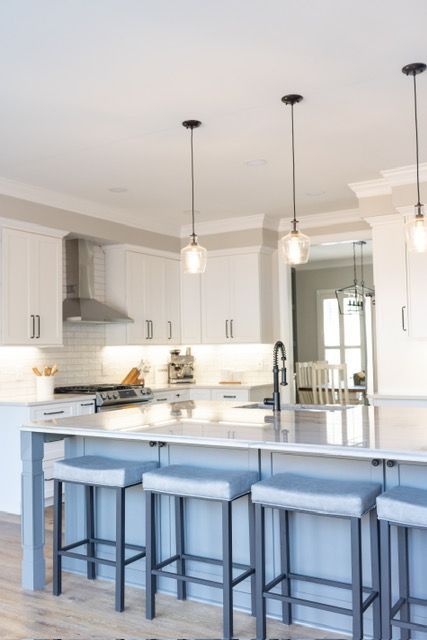 A kitchen with a large island and stools