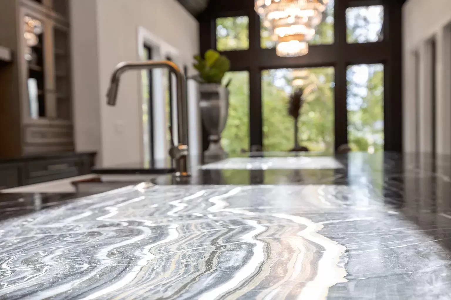 A kitchen with a marble counter top and a sink.