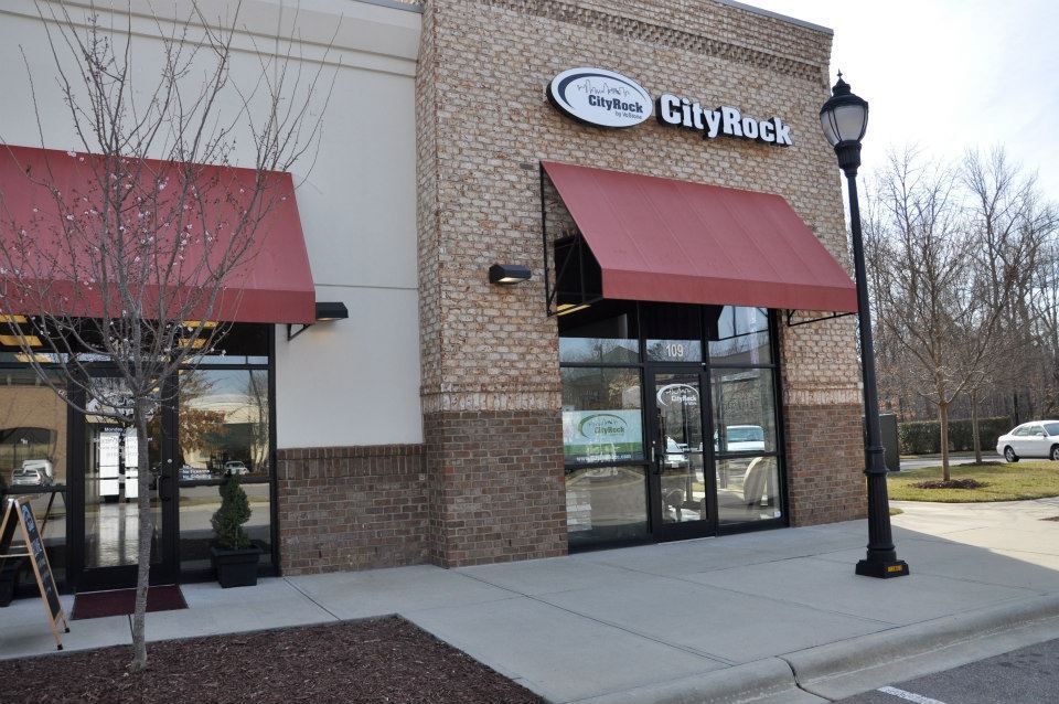 A city rock store with red awnings and a street light