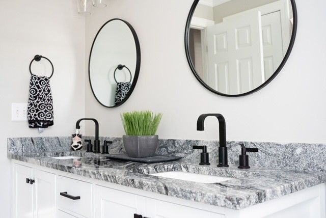 A bathroom with two sinks and two mirrors on the wall.
