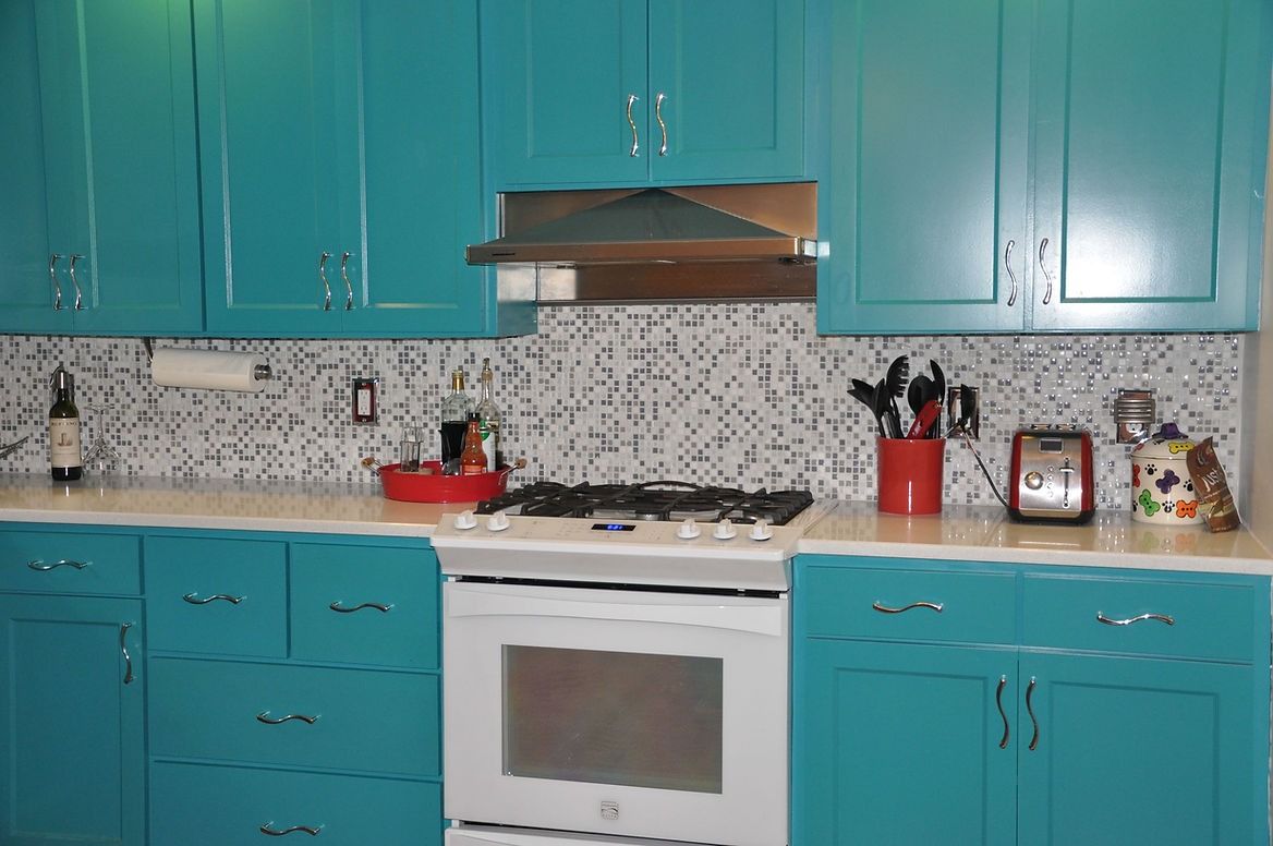 A kitchen with blue cabinets and white appliances.