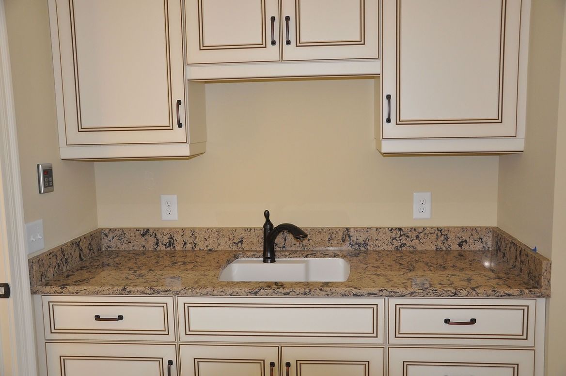A kitchen with granite counter tops and white cabinets