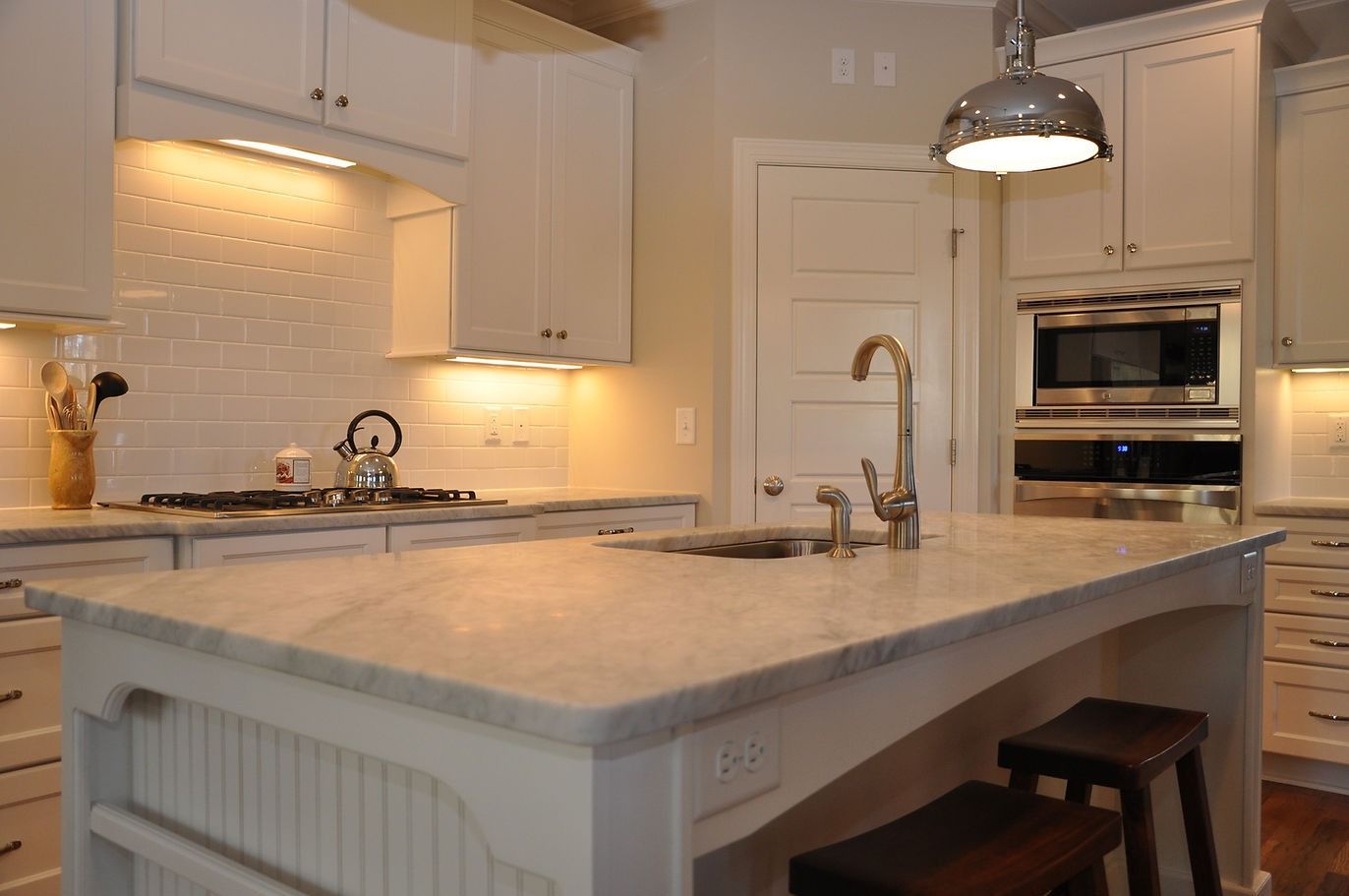 A kitchen with white cabinets and stainless steel appliances