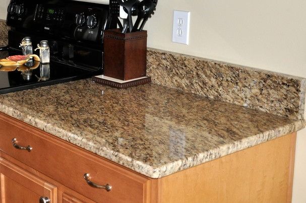 A kitchen counter with a granite counter top and a stove top oven