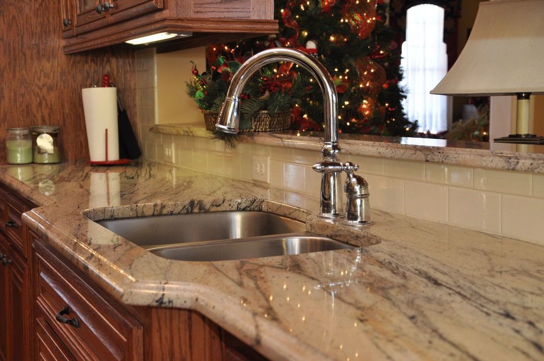 A kitchen with a sink and a christmas tree in the background