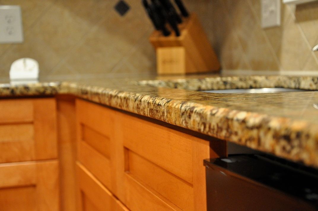 A kitchen with granite counter tops and wooden cabinets