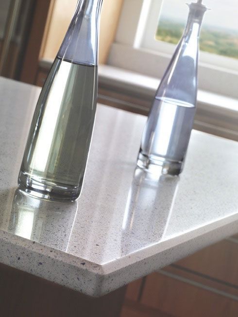 Two bottles of water are sitting on a counter