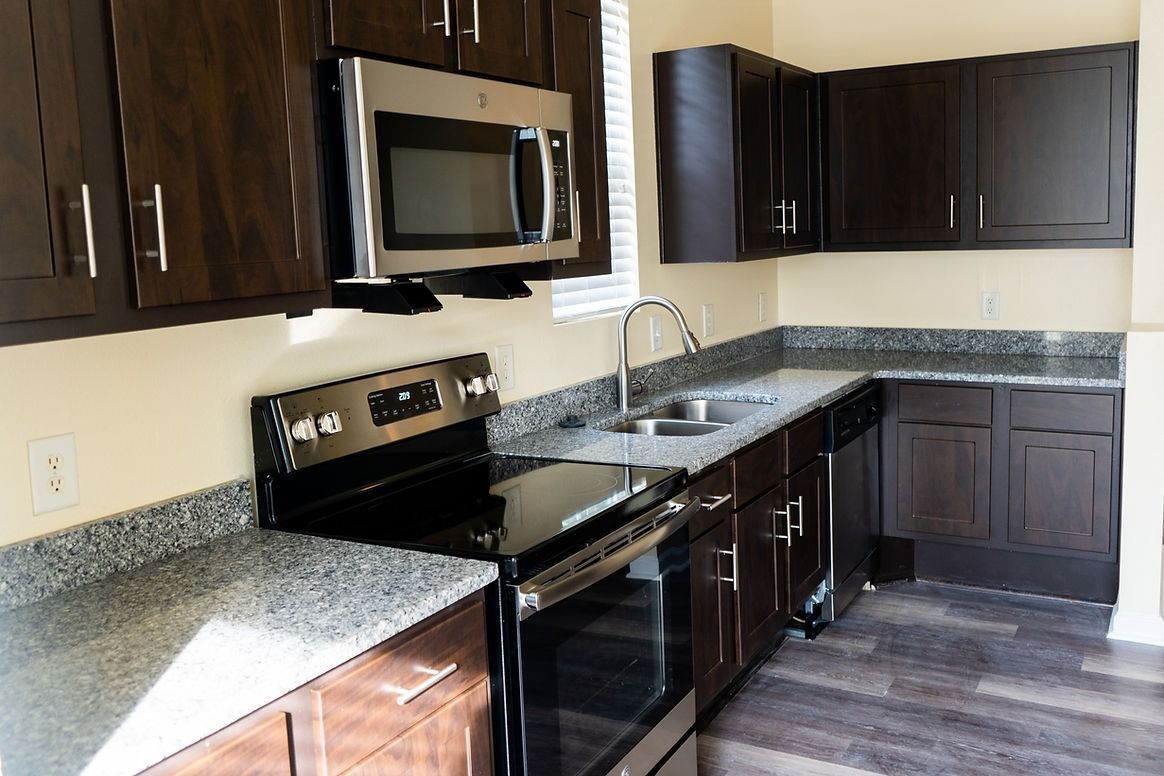 A kitchen with stainless steel appliances and granite counter tops.