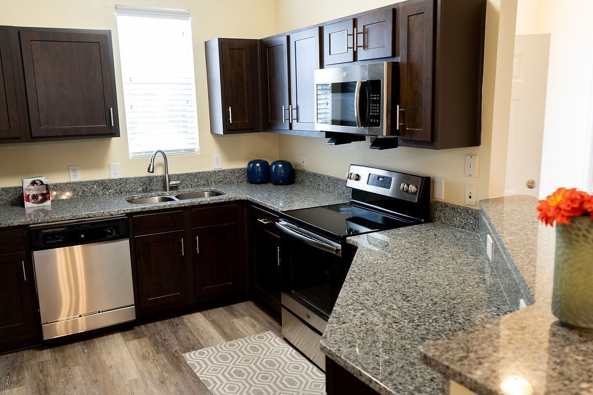 A kitchen with stainless steel appliances and granite counter tops.