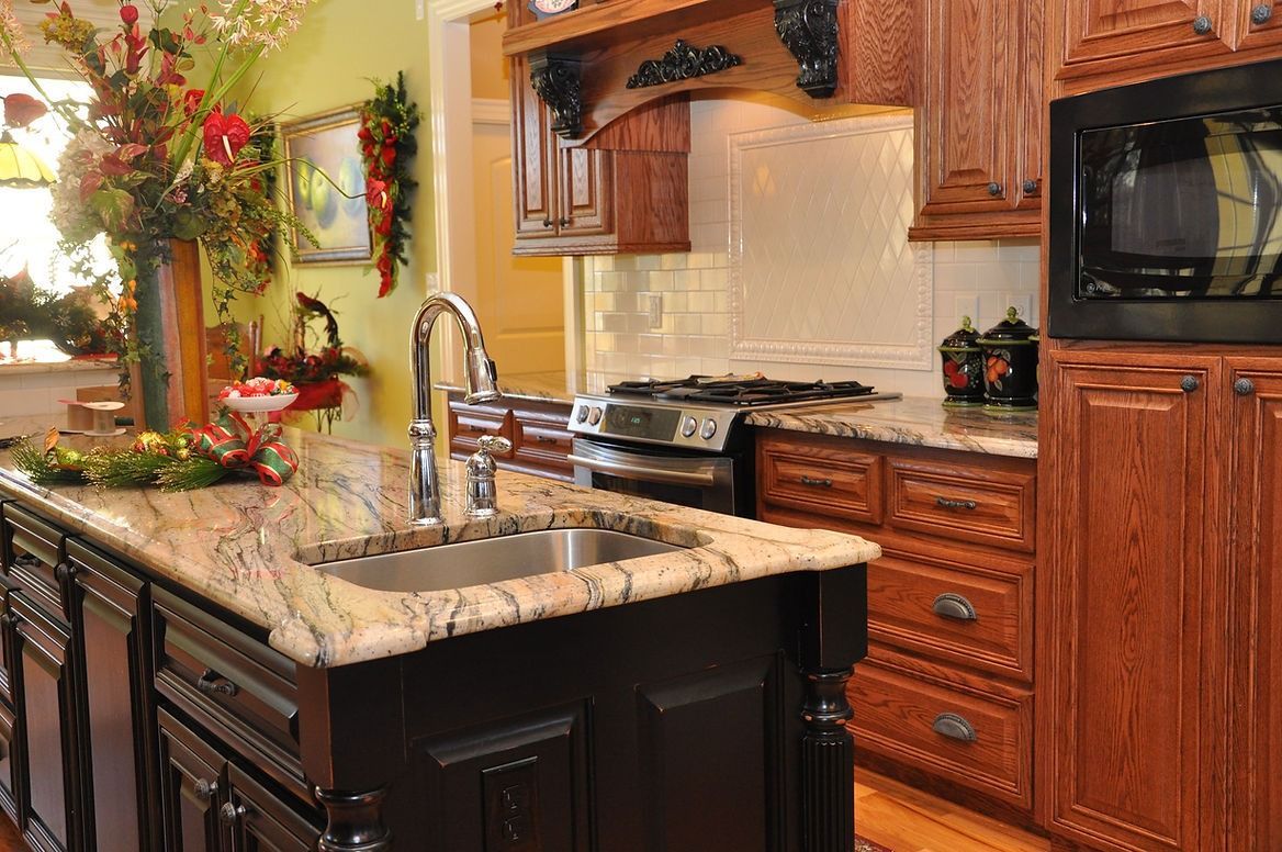 A kitchen with stainless steel appliances , granite counter tops , and wooden cabinets.