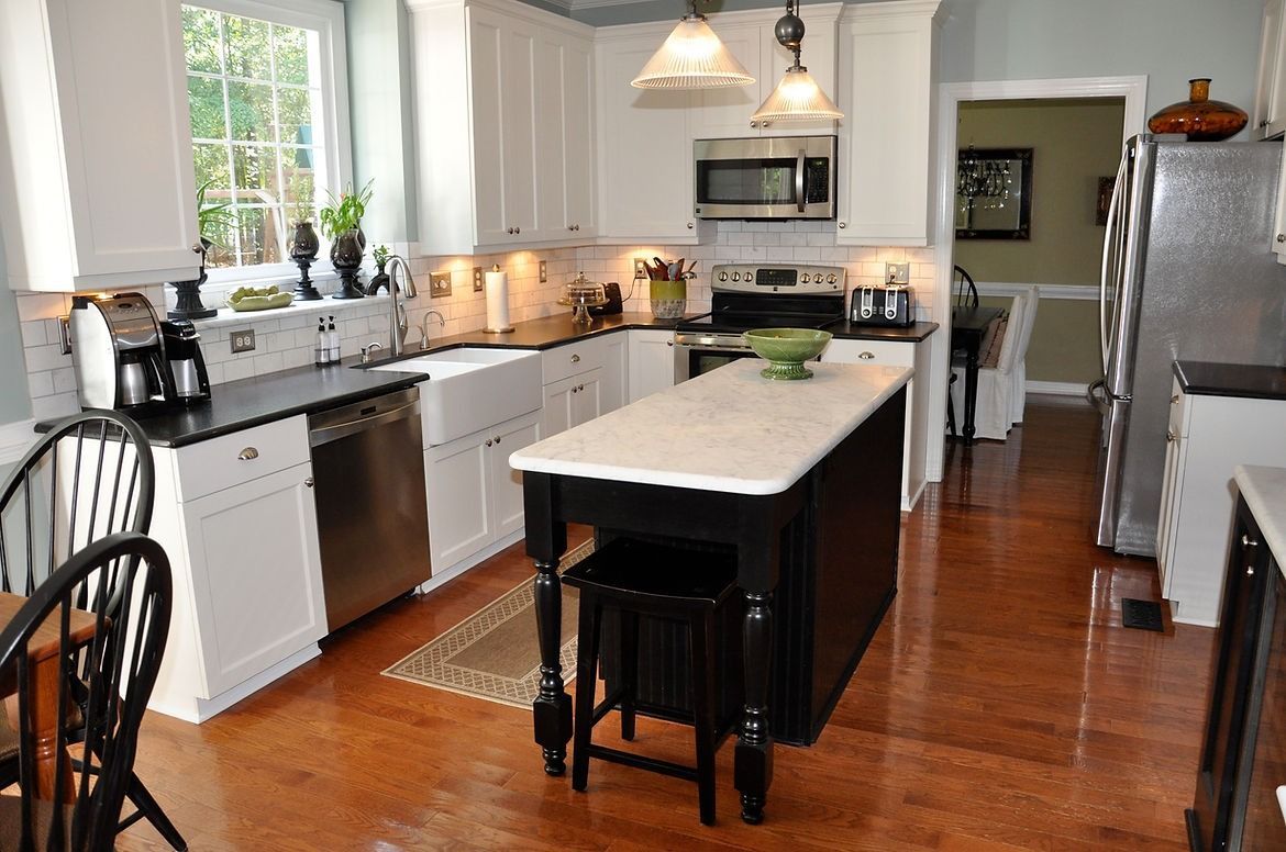 A kitchen with white cabinets and stainless steel appliances