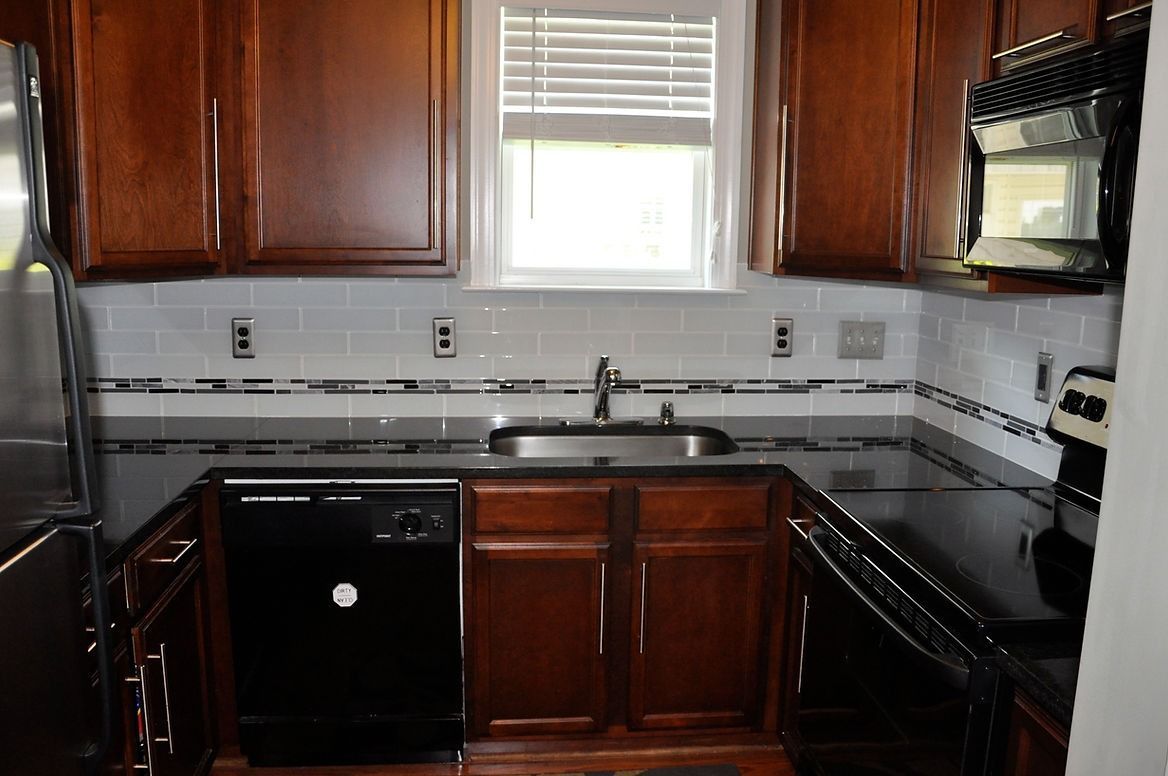 A kitchen with stainless steel appliances and wooden cabinets