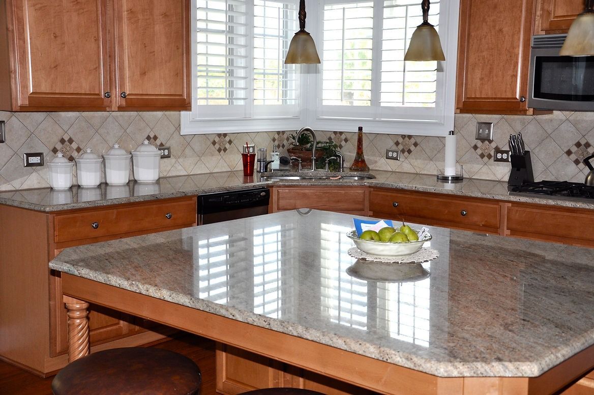 A kitchen with granite counter tops and wooden cabinets