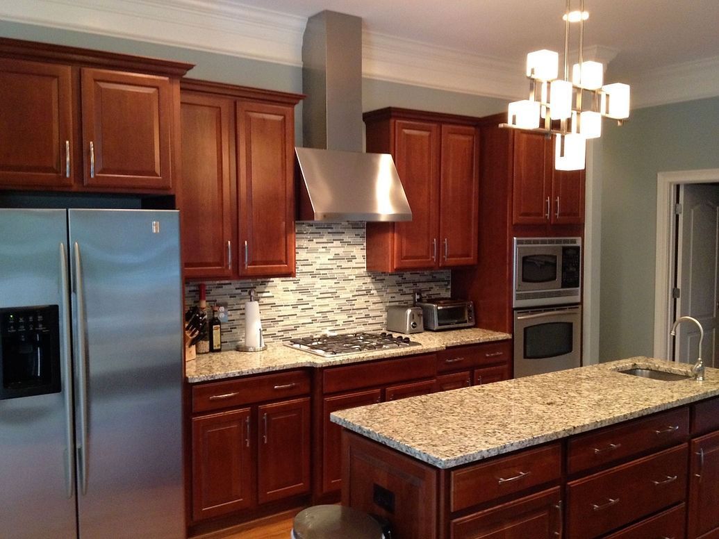 A kitchen with stainless steel appliances and wooden cabinets