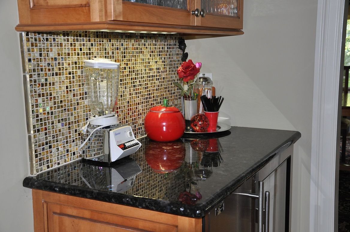 A kitchen counter with a blender and a tomato on it.