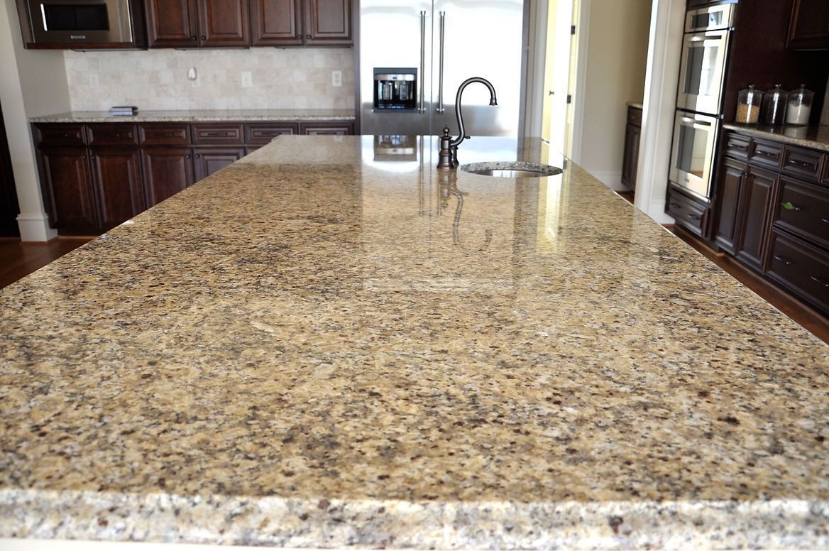 A kitchen with a large granite counter top and a sink.