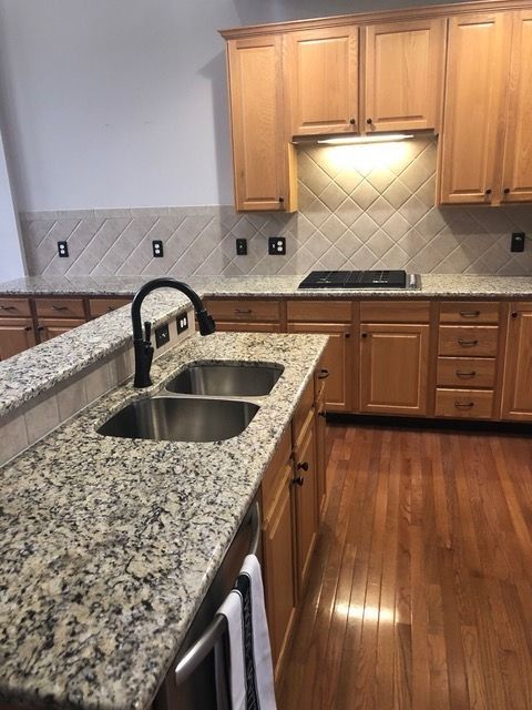 A kitchen with granite counter tops and two sinks