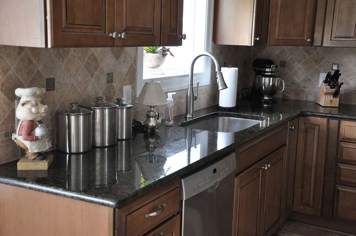 A kitchen with wooden cabinets and granite counter tops