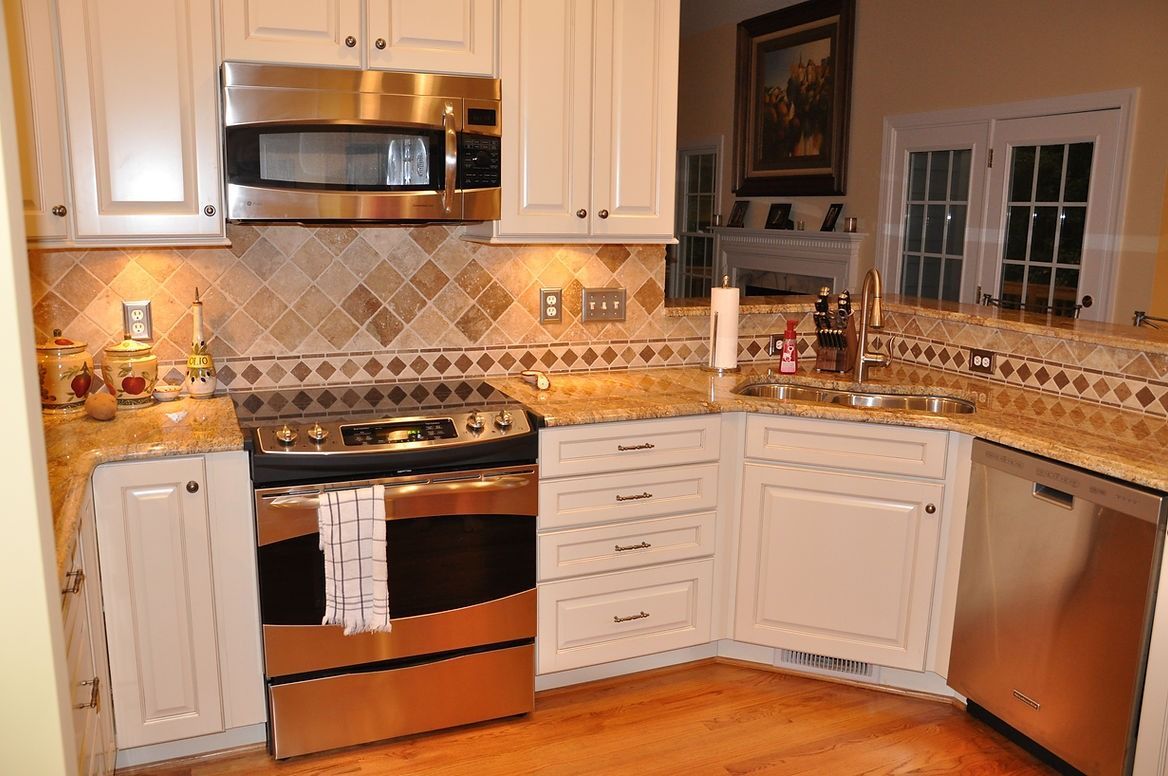A kitchen with stainless steel appliances and white cabinets