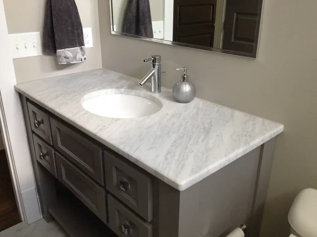 A bathroom with a sink soap dispenser and mirror
