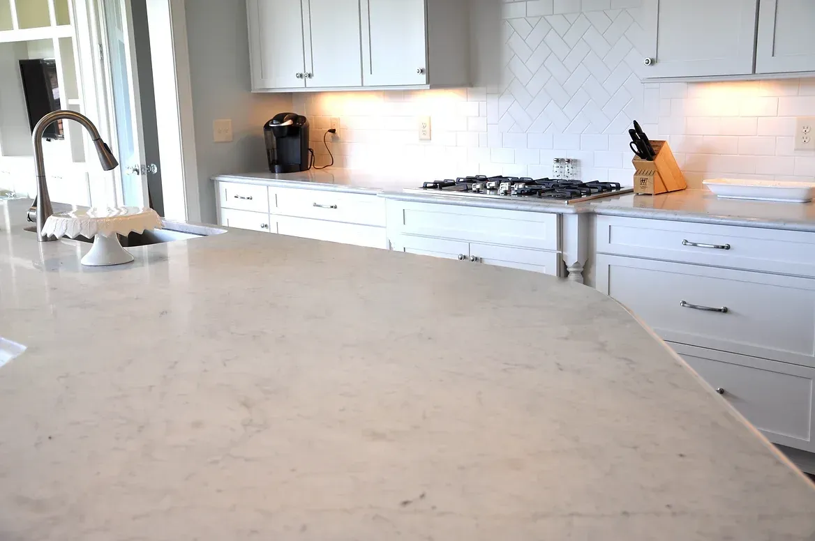 A kitchen with white cabinets and granite counter tops