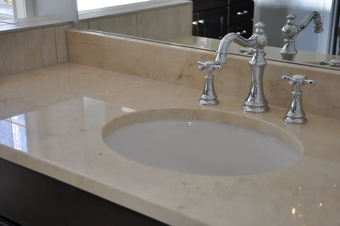 A bathroom sink with three faucets and a mirror
