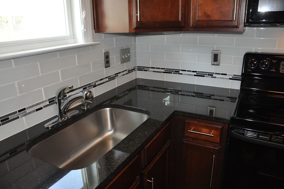 A kitchen with a sink and stove top oven