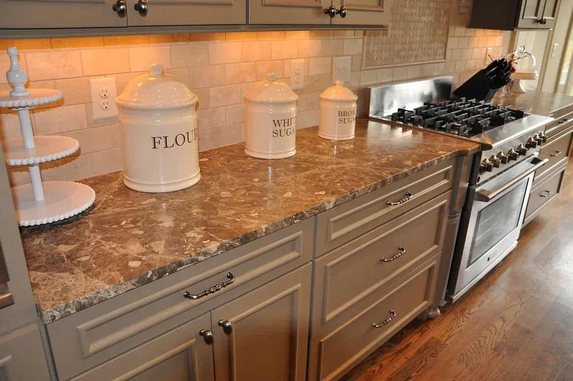 A kitchen with a stove and a marble counter top