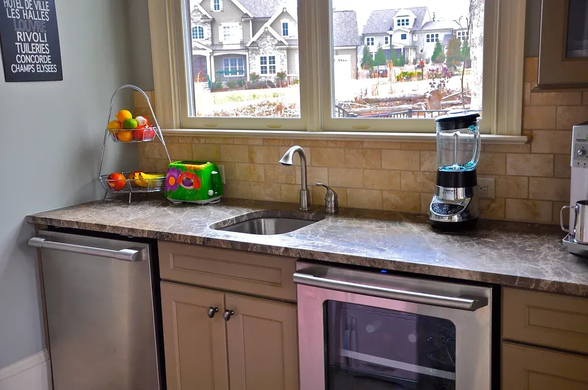 A kitchen with a sink , oven , dishwasher and blender