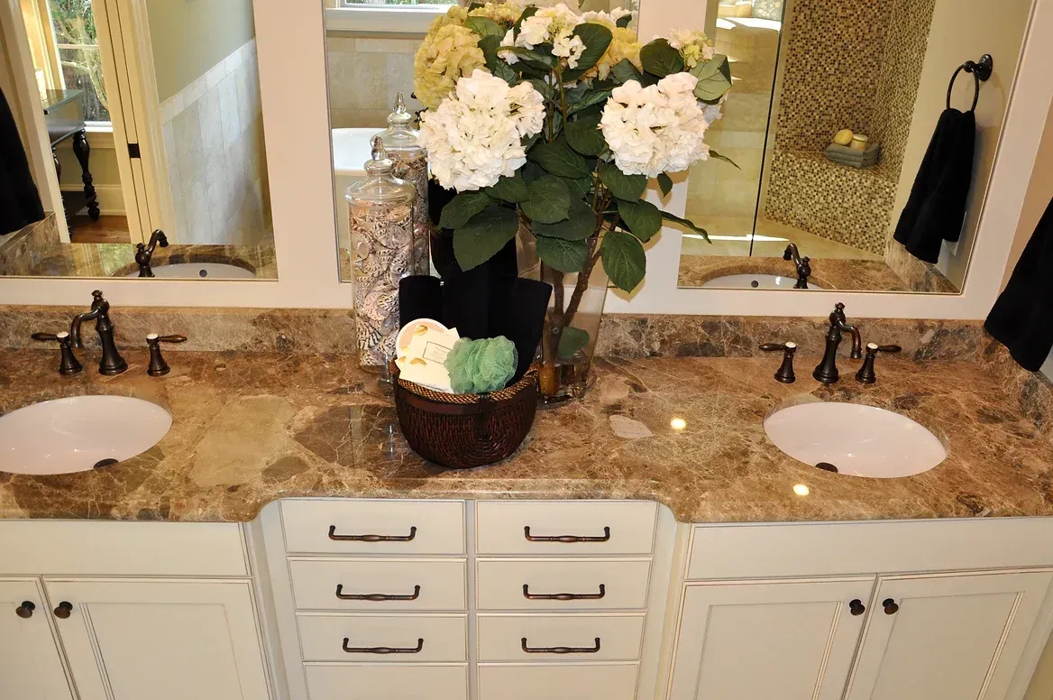 A bathroom with two sinks and a basket of flowers on the counter