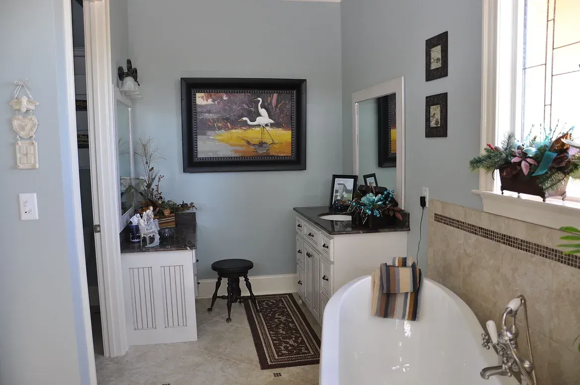 A bathroom with a tub and a picture on the wall