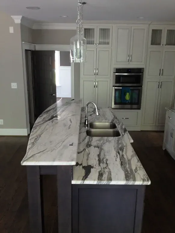 A kitchen with a marble counter top and two sinks