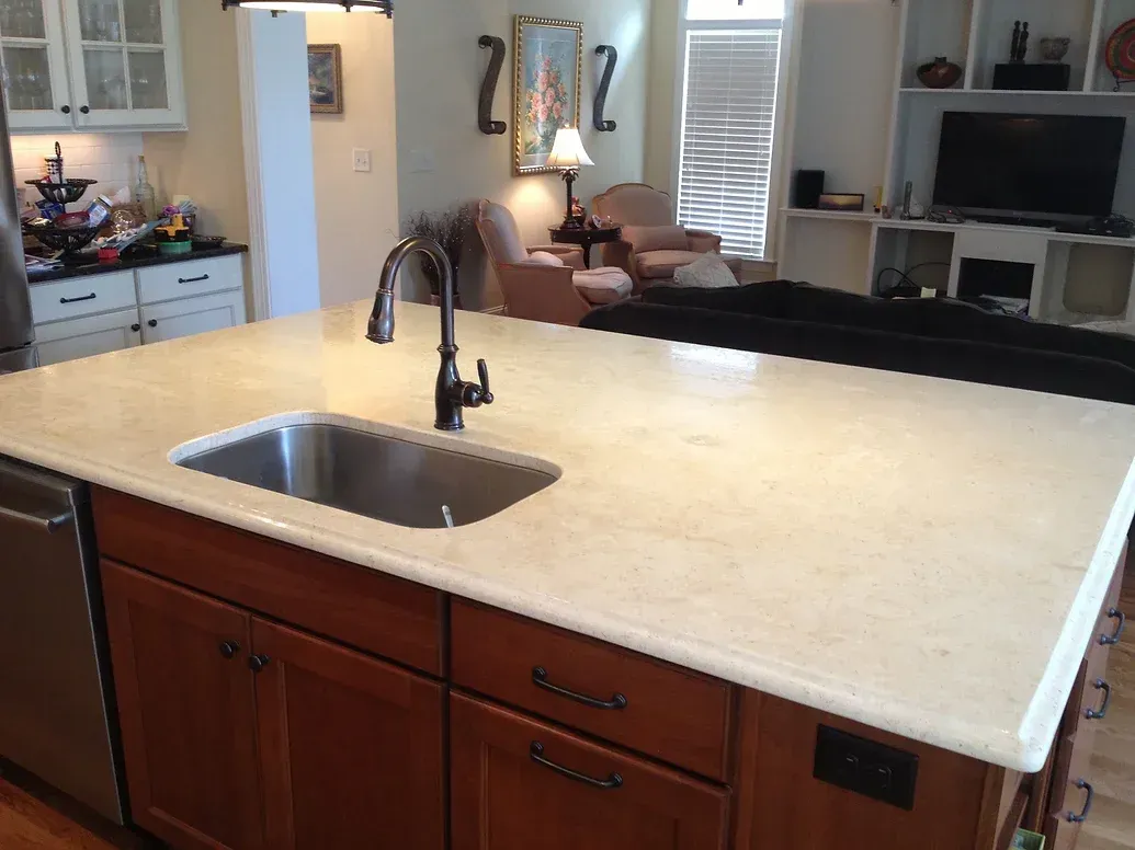 A kitchen with a stainless steel sink and wooden cabinets