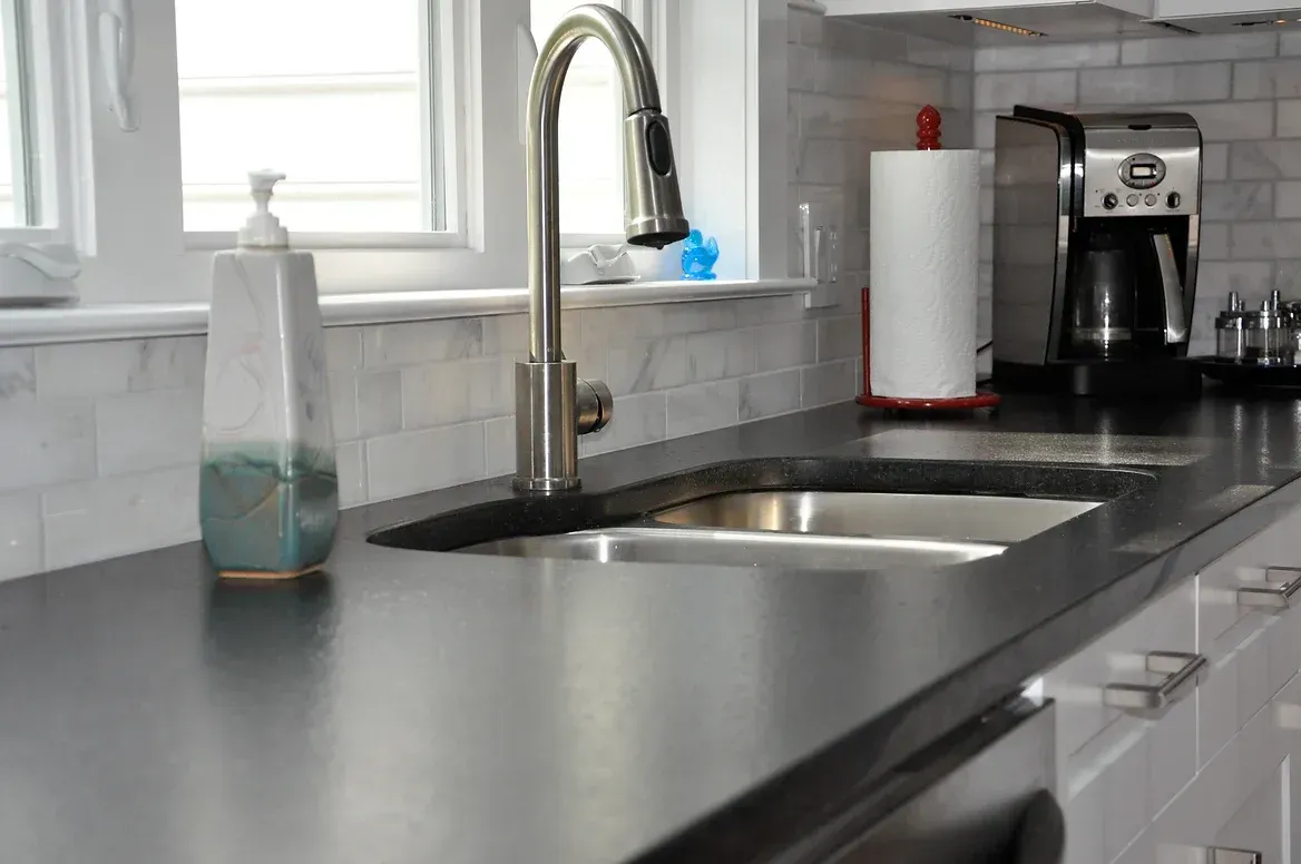A kitchen counter with a sink and a coffee maker