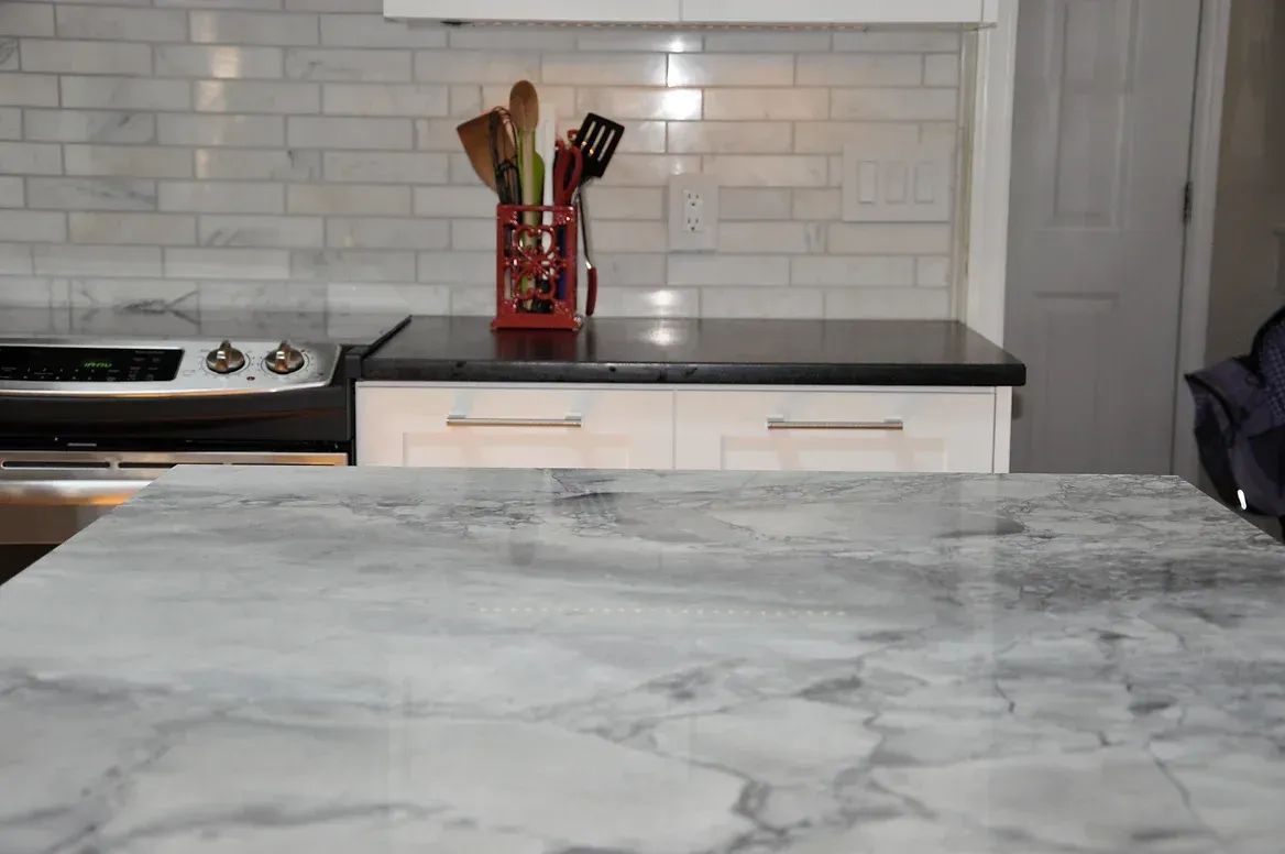 A kitchen with a marble counter top and a stove.