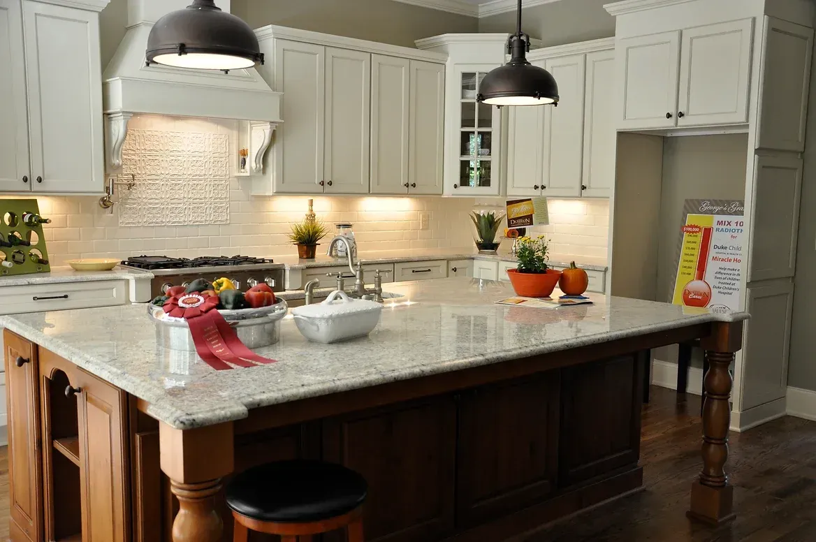 A kitchen with a large island and white cabinets