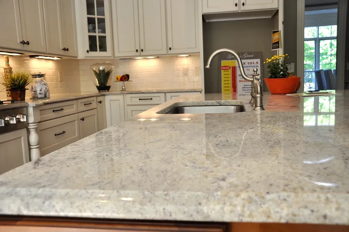 A kitchen with white cabinets and a granite counter top