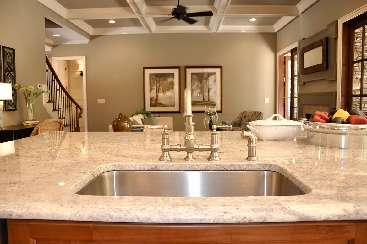 A kitchen with a stainless steel sink and granite counter tops